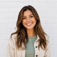 Portrait of Emily Carter smiling confidently in a modern indoor setting after sharing her successful experience with Webpromaze's social media marketing services.